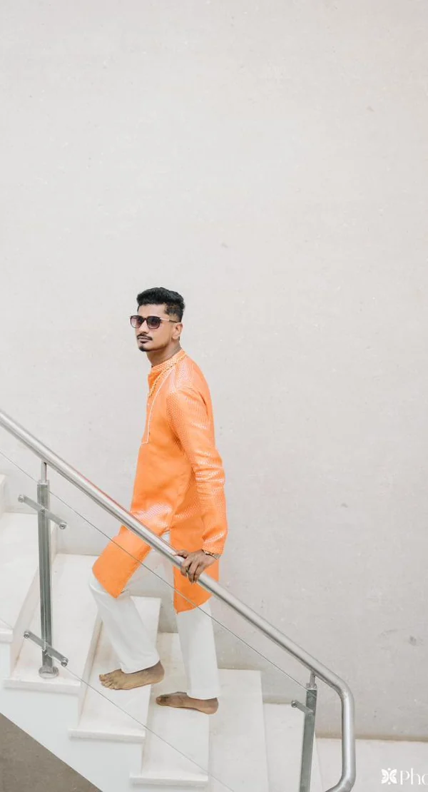 A client in a tailored orange kurta and churidar