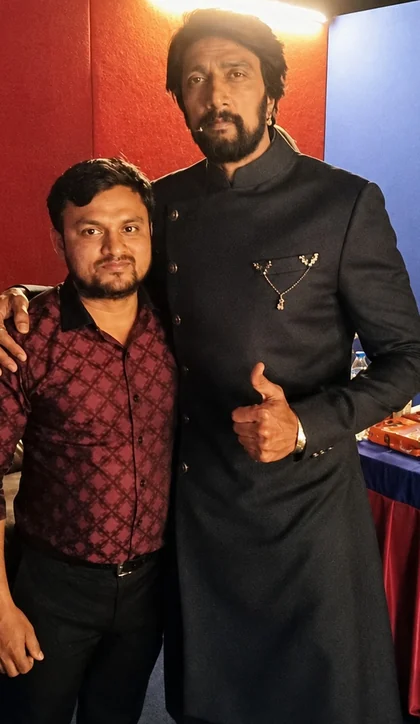 Kichcha Sudeep backstage in a dark bespoke bandhgala tailored by Arsu, standing with the studio's master tailor